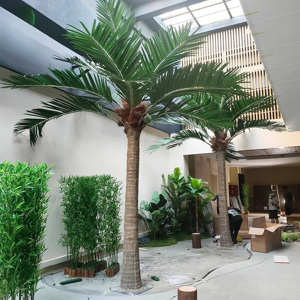 Artificial palm trees in an indoor setting with a modern architectural background.